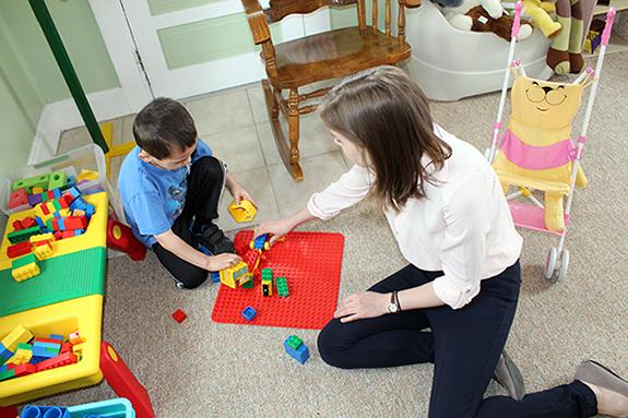 汉娜·布雷肯里奇是一名语言病理学研究生，她正在和一个孩子玩耍
